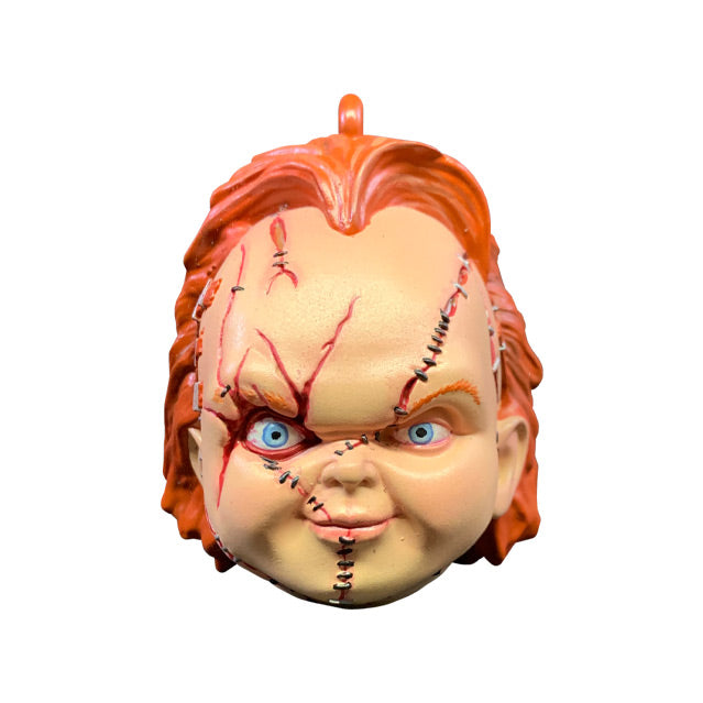 Ornament. Front view. Scarred Chucky head, red hair, blue eyes, scarred and stitched face.