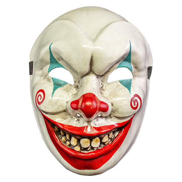 Plastic face mask, front view. Dirty white clown face, menacing grin, blue painted triangles above and below eyes, red on nose, large red painted smile with spirals on cheeks, dirty yellow teeth.