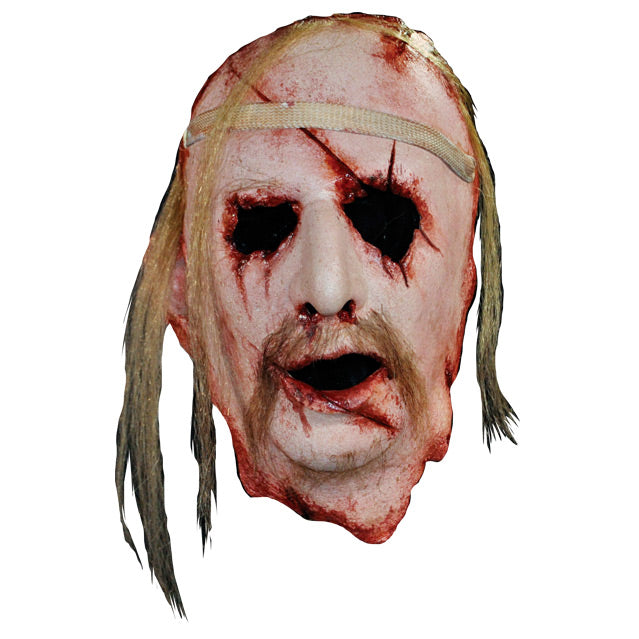 Face Mask, face and neck, front view. Man's face, bloody with cuts and wounds around forehead, eyes, nose , mouth and neck. Sparse locks of blond hair, long blond moustache. Bandage around forehead.