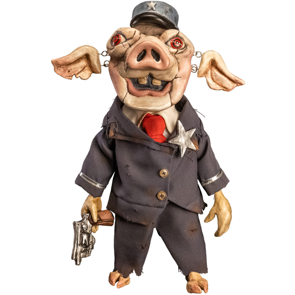 Mr. Snuggles puppet prop, front view. Pink pig face, red eyes, open mouth with two buck teeth, ears attached with metal links, blue hat with silver star. Wearing distressed blue suit, with silver trim and silver star, 2 gold buttons, dirty white shirt, red necktie, cloven hoof pig feet. Right hand holding wooden handled silver pistol.