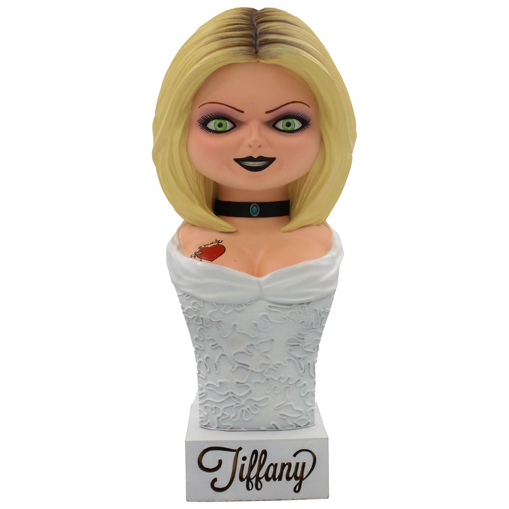 15 inch, Seed of Chucky, Tiffany bust, head, neck, and chest, blond hair, green eyes. Black eyeliner, pink eye shadow, Black lipstick. Black collar necklace. Red heart tattoo on right chest. Wearing a white wedding dress. Set on white base, cursive text reads Tiffany.