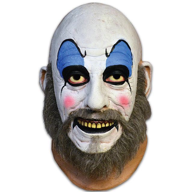Mask, head and neck. Bald man in white clown makeup, high black eyebrows, blue eyeshadow, black circles around eyes, pink spots on cheeks, large menacing grin, black bottom lip, full gray beard.