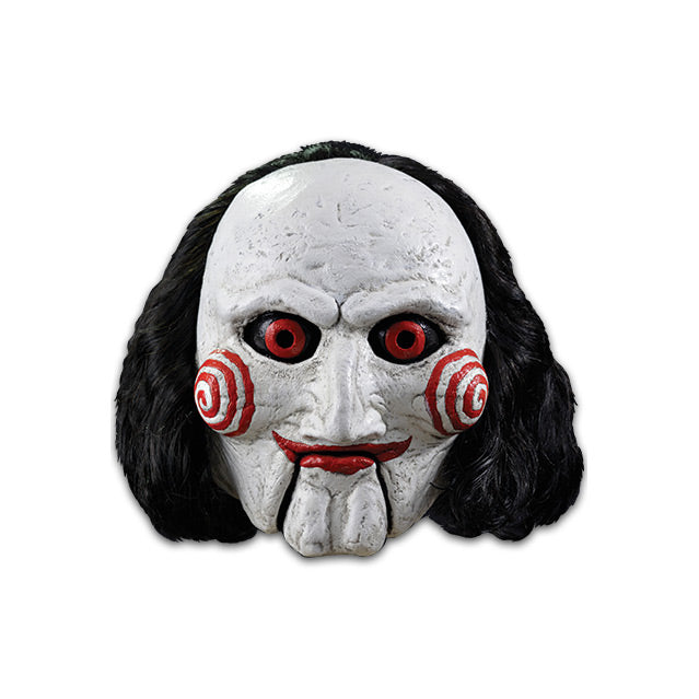 Mask, front view. Saw Billy puppet, balding with black hair, white face, black-rimmed red eyes, red spirals on cheeks, red lips on hinged ventriloquist dummy mouth.