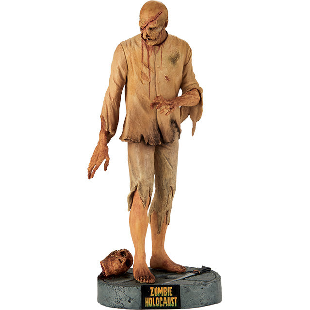 12 inch statue, front view.  Zombie, rotting flesh and wounds on face, dirty tattered beige shirt and pants, dirty bare feet. Standing on gray stone textured base with severed head and saw.  Black plaque on base with yellow text reads Zombie Holocaust.