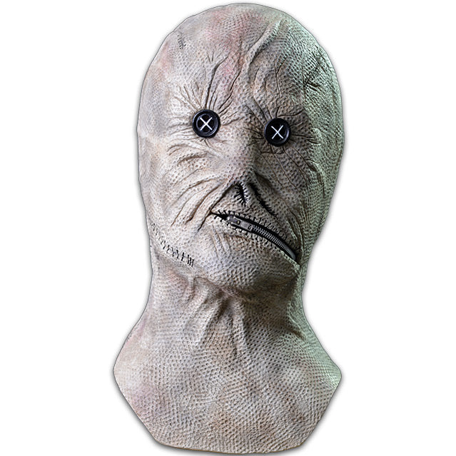 Mask, front view, head neck and upper chest.  White wrinkled leather textured skin, stitches on right jawline, black button eyes, crooked zipper for mouth, zipped closed.