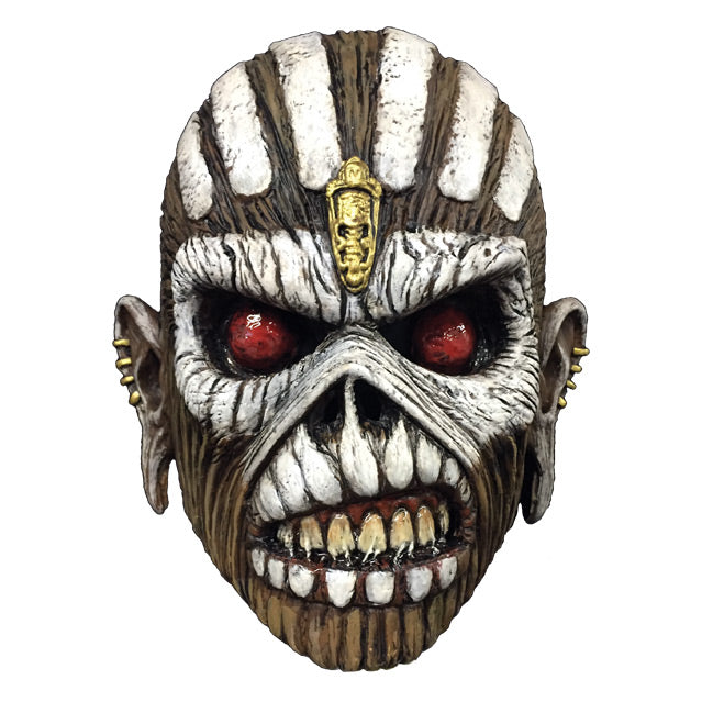 Mask, front view.  Iron Maiden Eddie, brown skin, white vertical lines on top of head, Gold embellishment in center of forehead, white paint around red eyes and across cheekbones, white painted teeth on upper and lower lips, mouth open showing teeth, stretched ears with gold studs on sides.