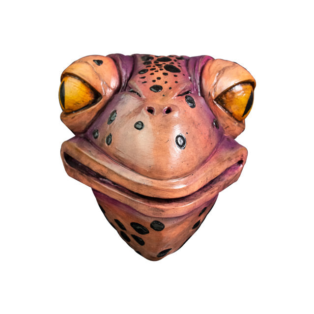 Mask, front view. Pale pink and purple toad face with black spots, large yellow eyes, 2 small nose holes between eyes. Large, wide mouth and neck.