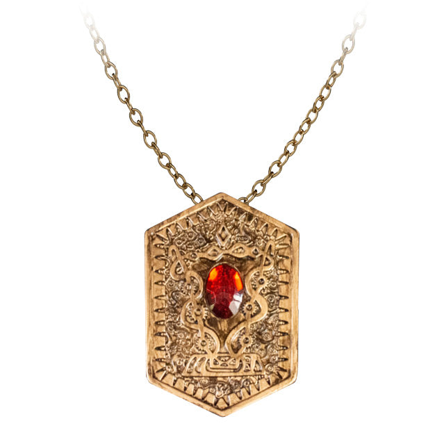 Heart of Damballa amulet prop, front.  Gold, hexagonal pendant, amber colored gem, gold chain.