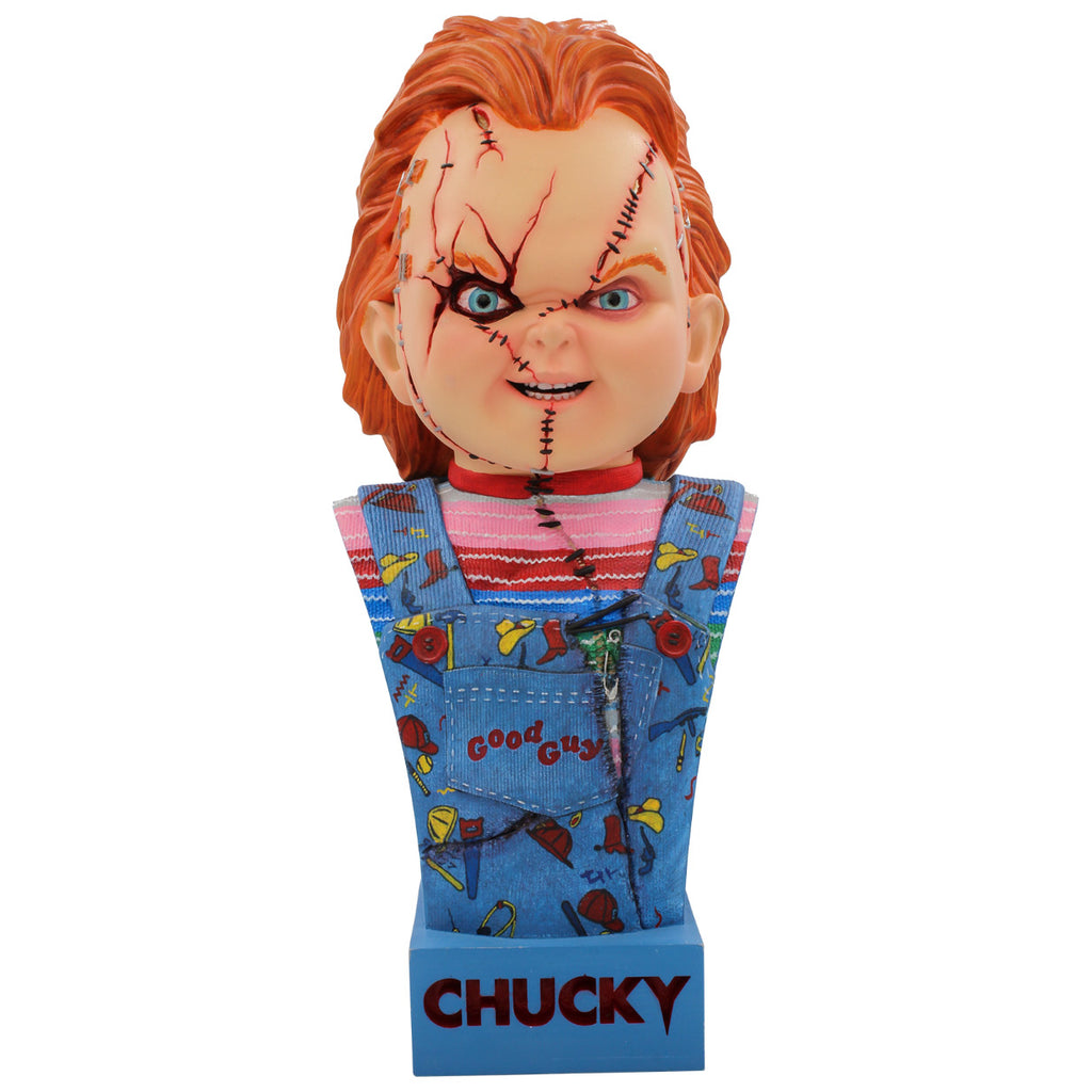 15 inch bust. Scarred Chucky, head, neck, and chest, red hair, blue eyes, scarred and stitched face. Wearing a red, white, blue and green striped shirt, ripped blue overalls with red buttons, red Good Guys printed on pocket. Set on blue base, red text reads Chucky.