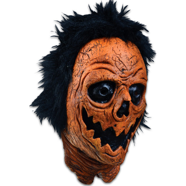 Mask, head and neck, right side view. Black hair, orange distressed flesh. Black eyes, nose and mouth made to resemble a jack o' lantern.