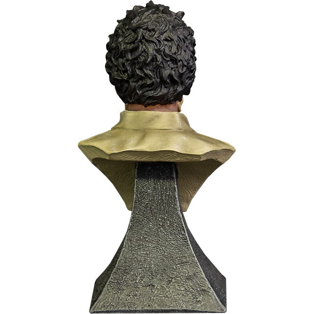 Mini Bust. Back view. Leatherface. Head, shoulders and upper chest of a man, black hair. Wearing a tan shirt.  Set on gray stone textured base.