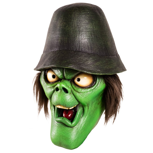 Mask, left side view. Green face with elongated chin, big white eyes, bushy brown hair, wearing a black hat.