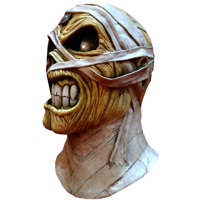 Mask, head and neck, left side view. Iron Maiden Eddie, tan skin large black eyes with highlights, scowling mouth with large white teeth, bandages on head face and neck.