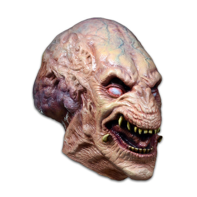 Mask, right side view, head and neck. Creature with enlarged upper head, pale flesh with blue veins showing through. White eyes, animal-like muzzle, open mouth showing sharp yellow teeth.