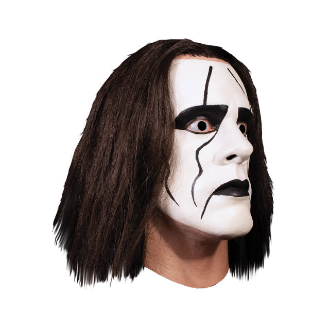Mask, head and neck, right view. Long dark brown hair, white face paint with black around eyes and mouth