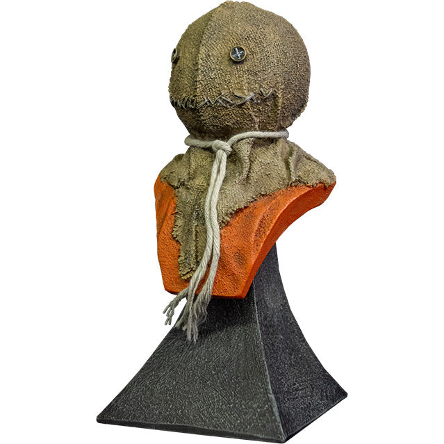 Mini bust.  Left view. Trick r' Treat Sam bust, head shoulders and upper chest. Head is a stitched burlap sack, Button eyes, stitched mouth, rope tied around neck, orange shirt. Set on gray stone textured base.