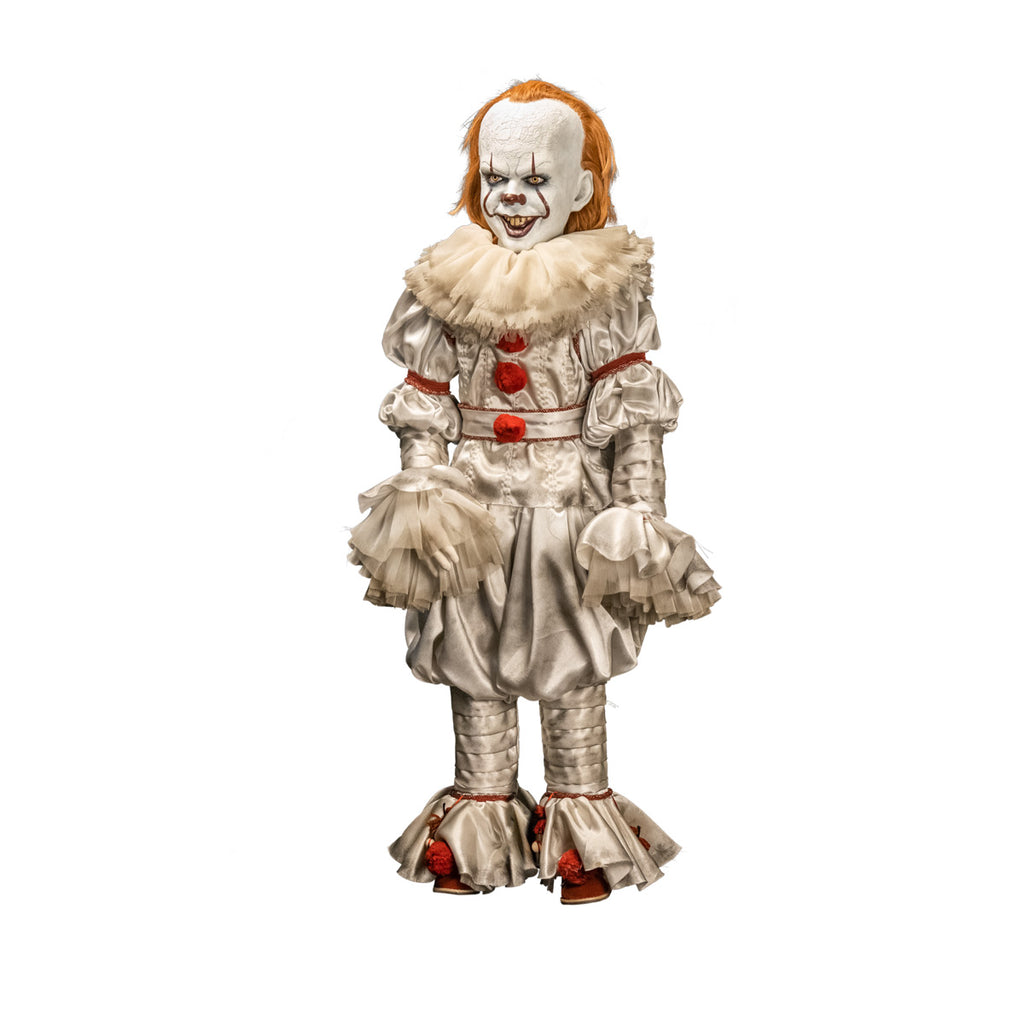 Pennywise doll, slight left view. clown face, red hair, white skin, large forehead, yellow eyes and nose, dark lips, creepy smile with crooked buck teeth. wearing white and red clown outfit with ruffles at collar and cuffs, red shoes.
