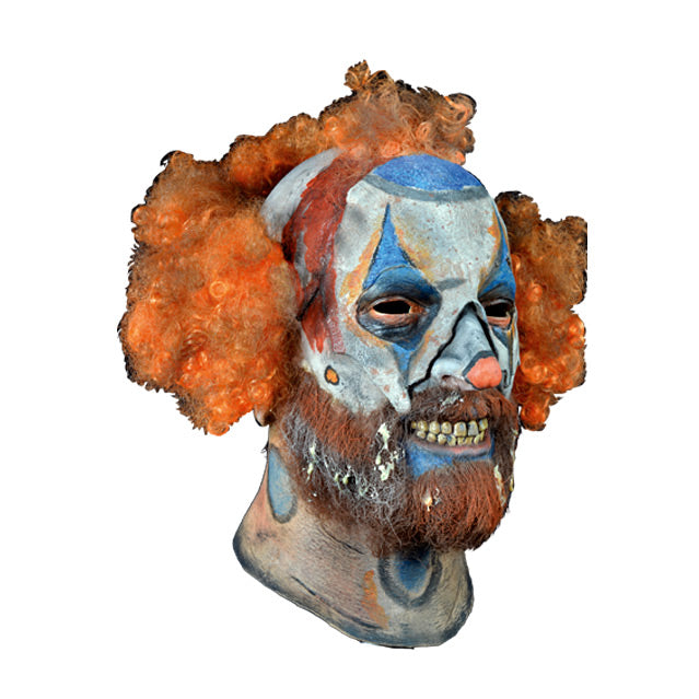 Mask, head and neck, right view. Disheveled clown mask, sparse curly red hair, white clown makeup, blue triangles painted around eyes, blue around mouth, menacing grin, beard and moustache.