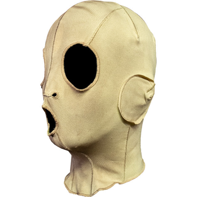 Mask, left view. Cloth, sewn mask, off-white fabric, with black eye, nose and mouth holes.