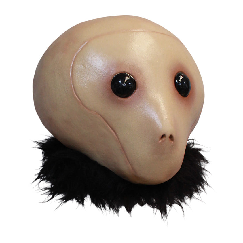 Mask, right view, head and neck. Tan head large black eyes, small nostrils, no mouth. Fur collar around neck.