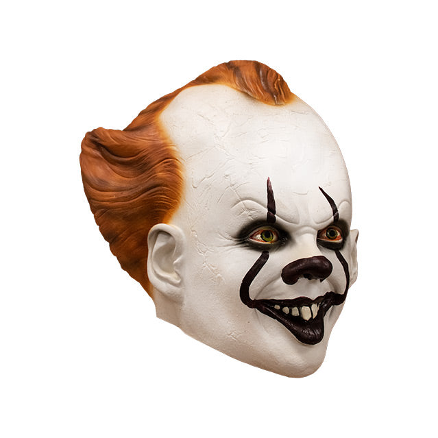 Mask, right side view. IT clown face, red hair, white skin, large forehead, Dark red nose, dark lips, creepy smile with crooked buck teeth.