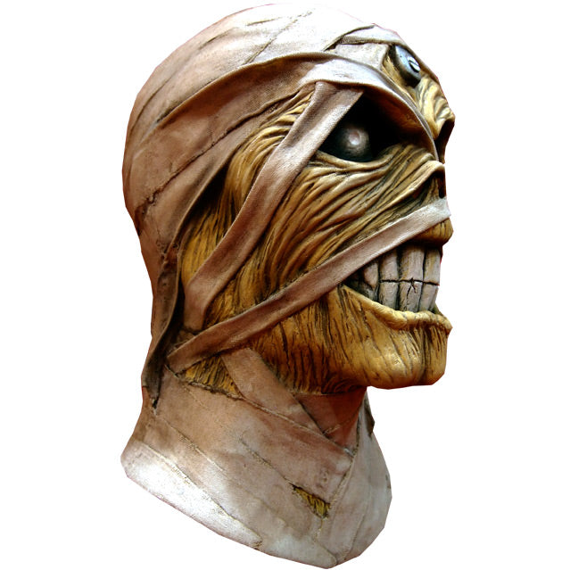 Mask, head and neck, right side view. Iron Maiden Eddie, tan skin large black eyes with highlights, scowling mouth with large white teeth, bandages on head face and neck.