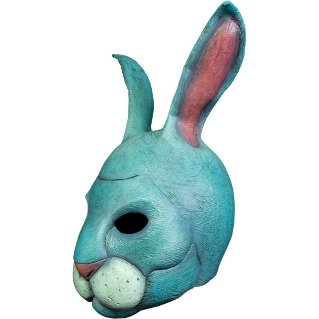 Mask. Left view. Light blue rabbit face and upright ears. Pink nose and inside of ears. Full round rabbit upper lip, white with whisker spots.
