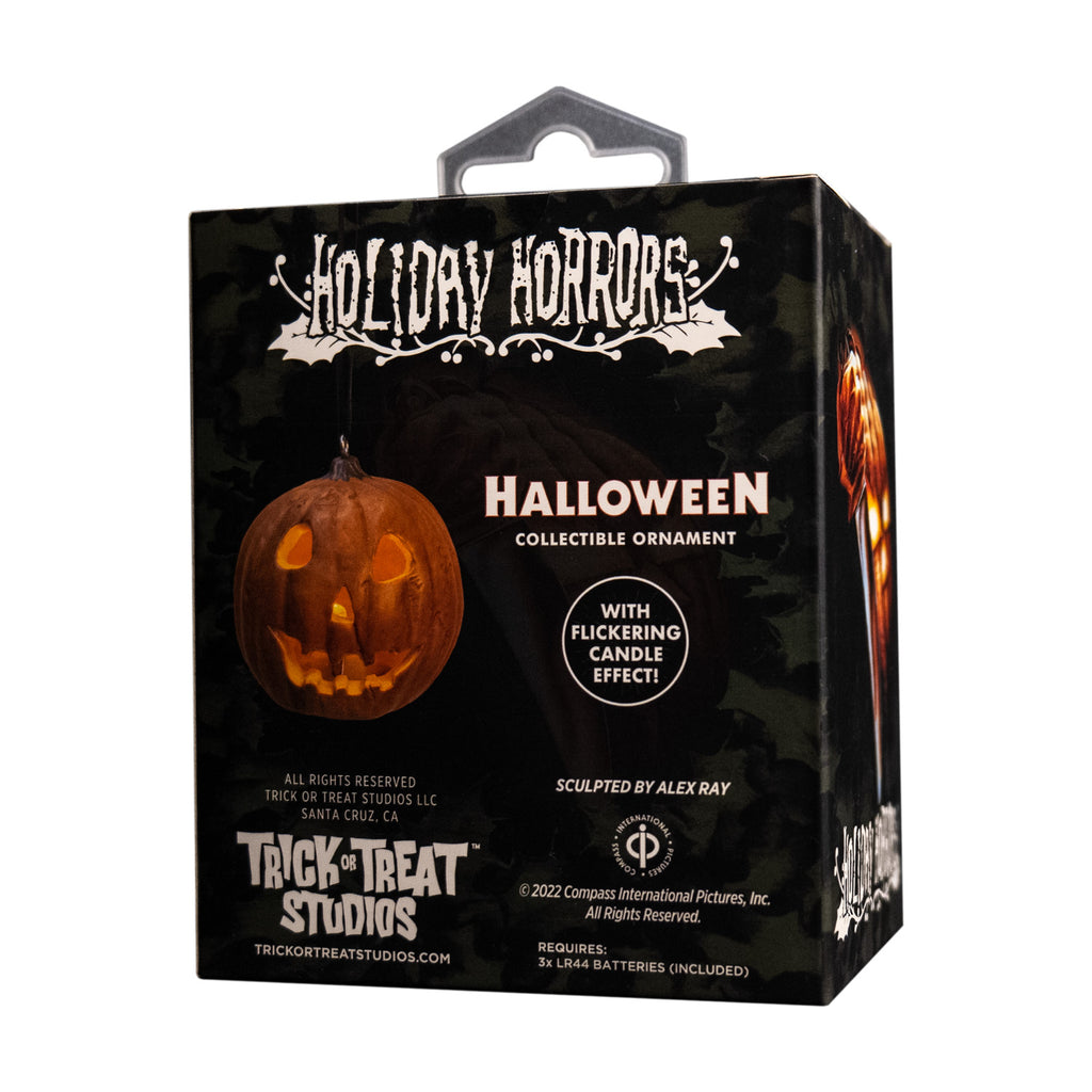 Product packaging, back. Black box, showing ornament. White text reads, Holiday Horrors, Halloween, collectible ornament, with flickering candle effect.  Manufacturing and licensing information