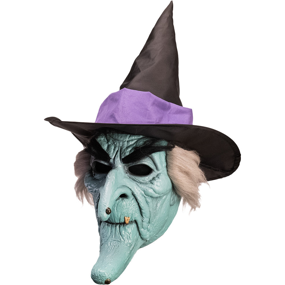 Mask, left side view. Pale green witch face with elongated chin, bushy black eyebrows and warts, gray hair, wearing black witch hat with purple band.