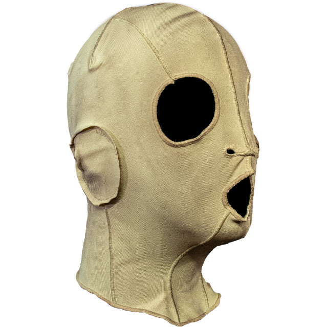 Mask, right side view. Cloth, sewn mask, off-white fabric, with black eye, nose and mouth holes.