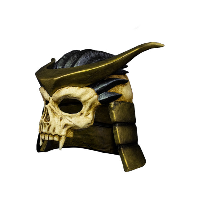 Plastic mask, left side view. Covers upper face and head. Skull with fangs, no bottom jaw. Wearing gold and black helmet.
