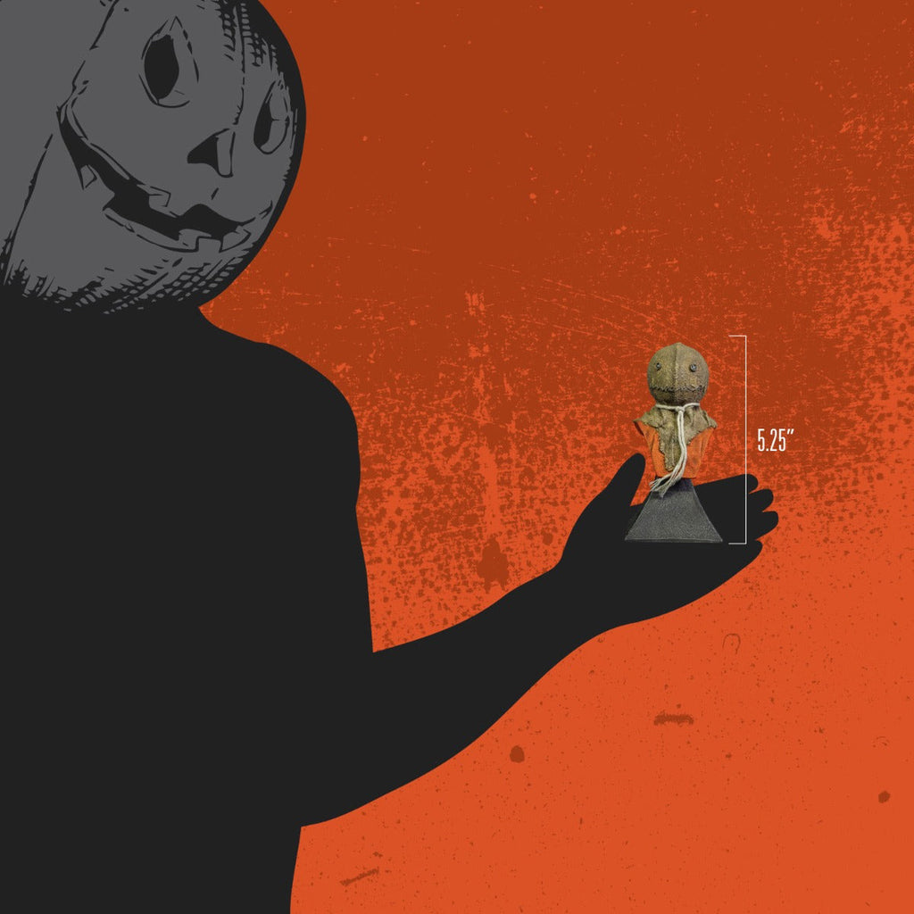Orange background. Person wearing black, jack o' lantern head, holding mini bust to show size, 5.25 inches