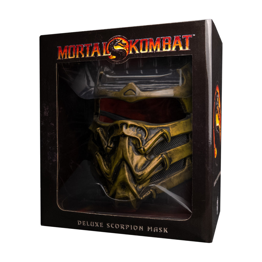 Product packaging, front. Black window box shows mask. Text reads Mortal Kombat Deluxe Scorpion mask.