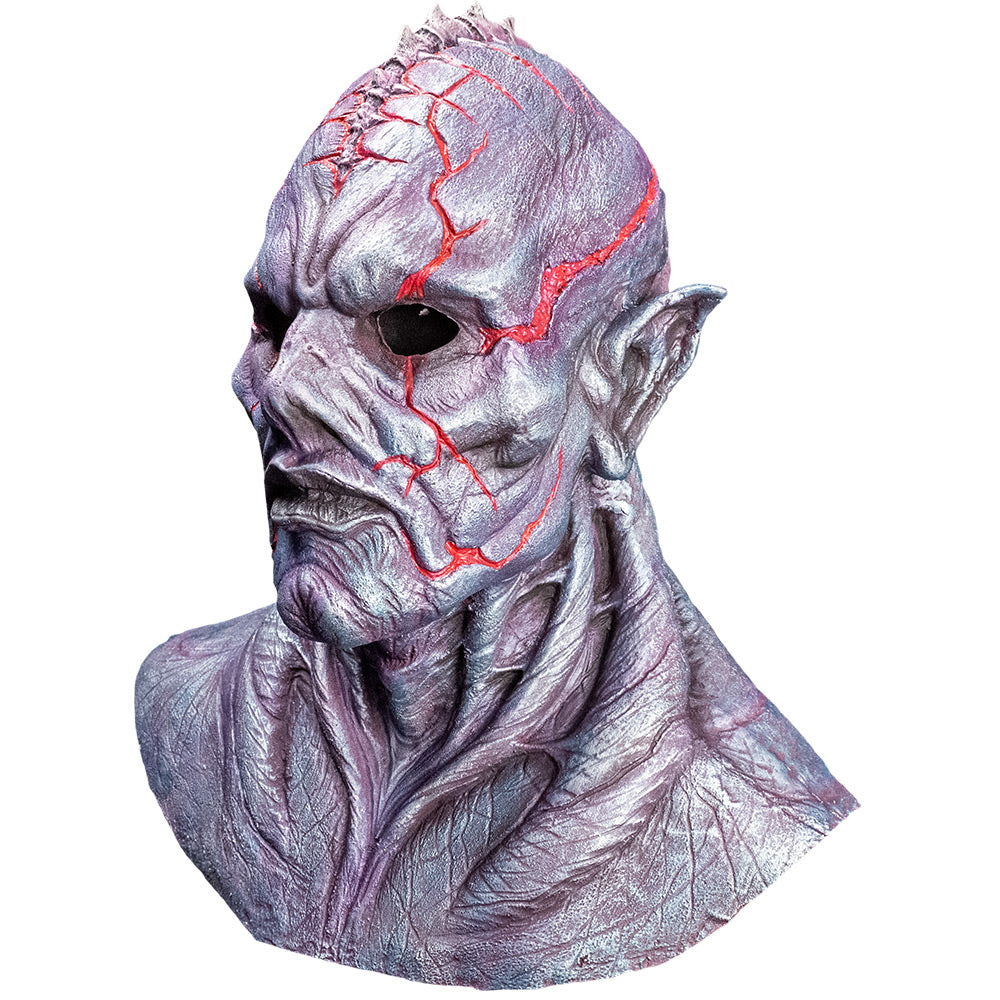 Mask, front left view, head, neck and upper chest. Silvery gray skin with bulging veins, bald with ridge on top of head, pointed ears, sharp cheekbones and cleft chin, red lines on head and face.