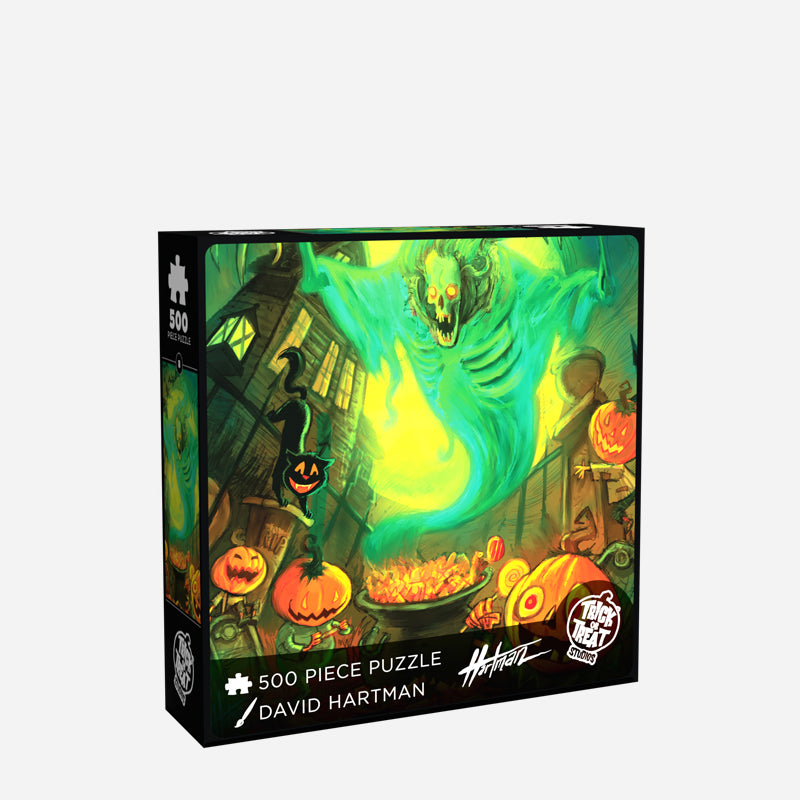 jigsaw puzzle box front. Illustration, green, orange, yellow, and black scene. Skeleton ghost in blue smokey robe hovering over cauldron, multiple jack o' lanterns in the foreground. black cat, spooky house, bats and a wall in the background White text reads 500 piece puzzle, David Hartman, White Trick or Treat Studios logo. 