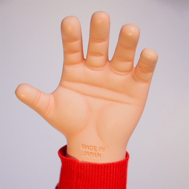 Close up of open left hand of doll. text on wrist reads , Made in Japan.