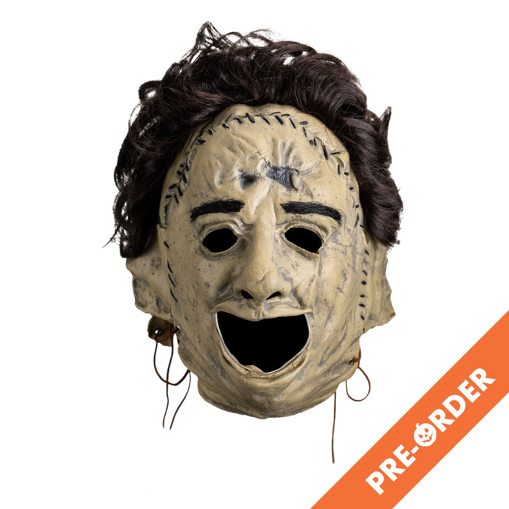 white background, orange diagonal banner at bottom right, white text reads pre-order.  Mask, front view, short brown bushy hair, black eyebrows, skin is sewn together, stitches around forehead and ears, open space for mouth.