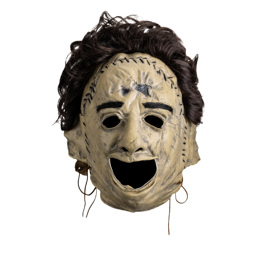 Mask, front view, short brown bushy hair, black eyebrows, skin is sewn together, stitches around forehead and ears, open space for mouth.