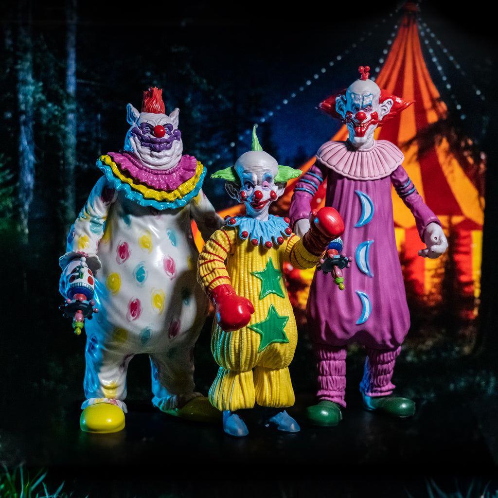 glamour shot. Nighttime circus scene in background. Three killer Klowns figures, Fatso, Shorty, and Slim in the foreground