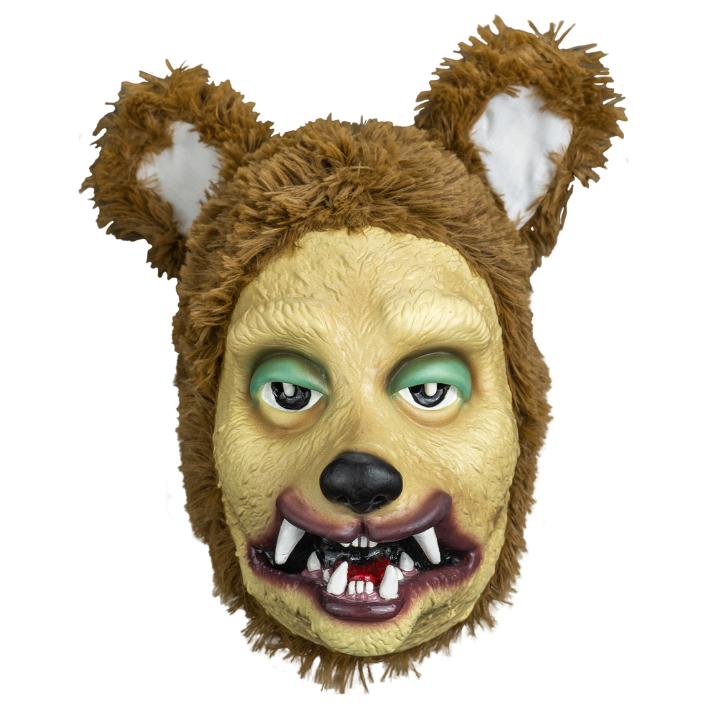 mask front view.  stylized dog face tan, green eyelids, black nose, purple lips, mouth open showing red tongue and crooked canine like teeth  surrounded with plush fur large brown and white ears on top of head.