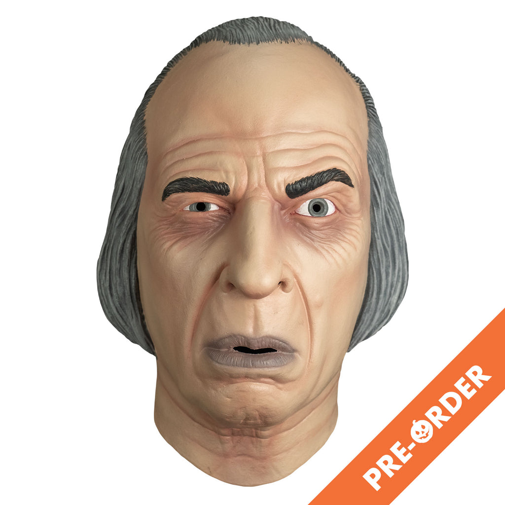 white background, orange diagonal banner at bottom right, white text reads pre-order.  mask, front view. receding hairline, gray hair. wrinkles on forehead and around eyes. Black eyebrows, left eyebrow raised. blue-gray irises, mouth slightly open with grayish lips