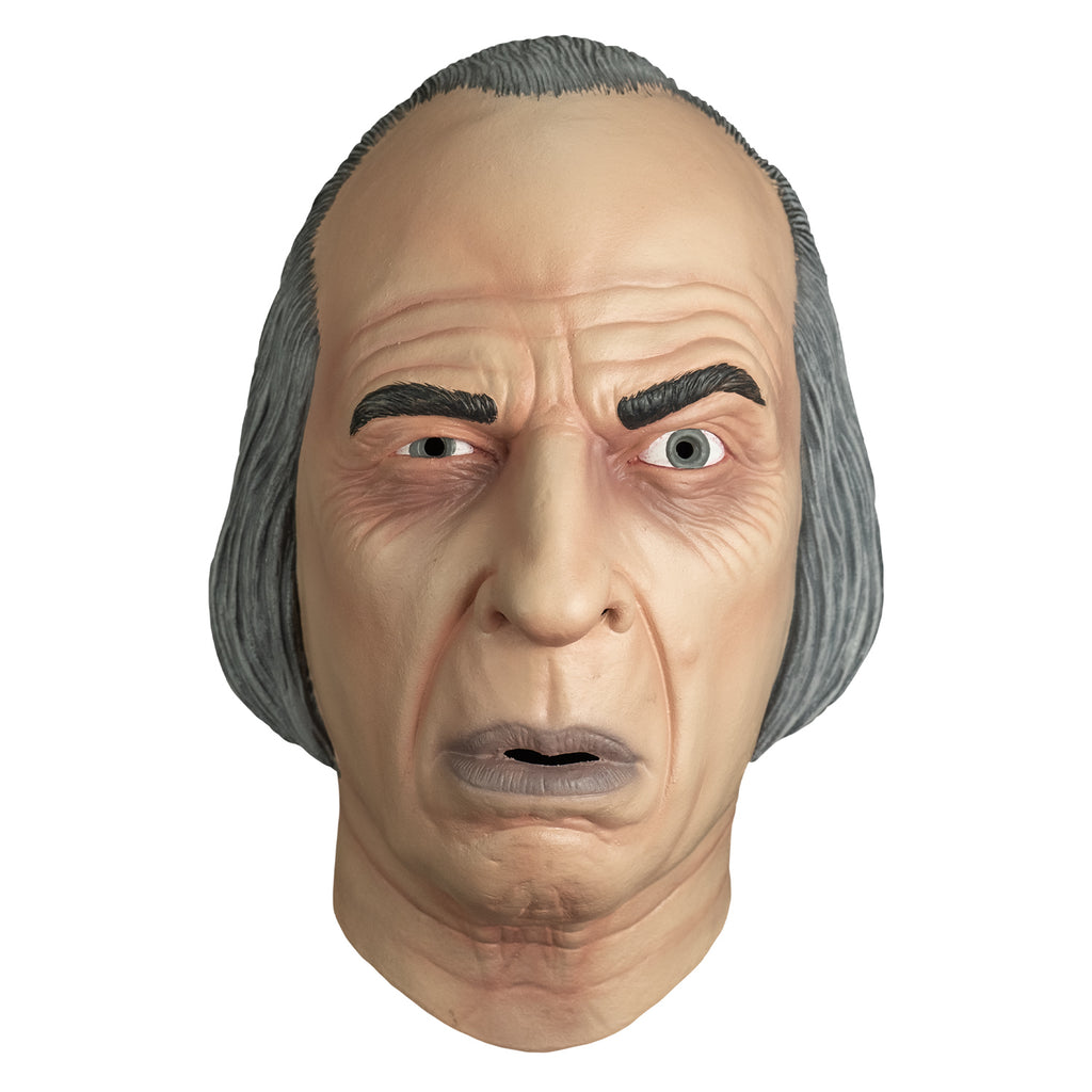 mask, front view.  receding hairline, gray hair.  wrinkles on forehead and around eyes.  Black eyebrows, left eyebrow raised. blue-gray irises, mouth slightly open with grayish lips