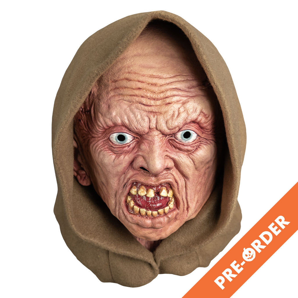 white background, orange diagonal banner at bottom right, white text reads pre-order.  mask, front view. wearing tan hood. pink highly wrinkled flesh. no eyebrows, pale blue irises, mouth open in a snarl showing crooked yellowed teeth an shiny wet looking red tongue.