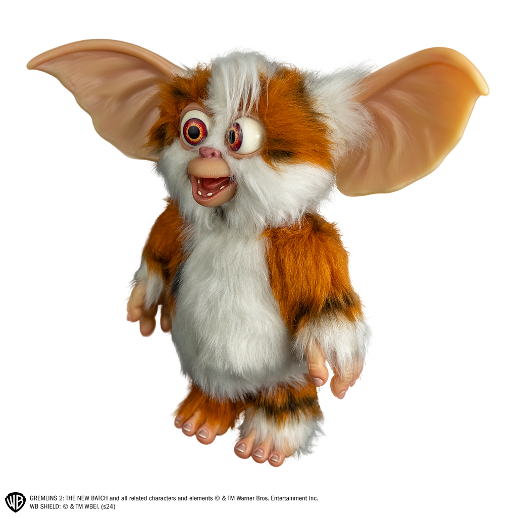 Gremlins 2 prop - Mogwai Daffy, full body, standing, left side view, brown and white with some black fur, large crossed eyes, mouth open in a smile, large pointed tan ears. Hairless hands and feet.