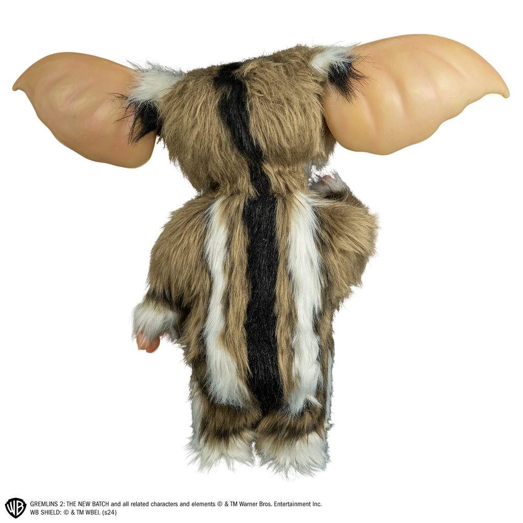 Lenny mogwai prop, back view, full body, black stripe down his back, light brown and white fur, large pointed tan ears.  Hairless hands and feet. 