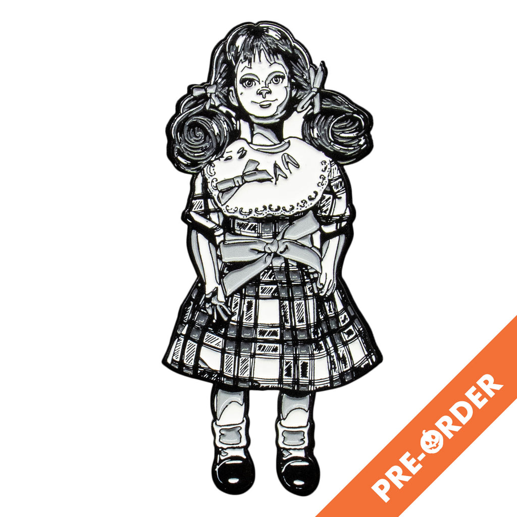 white background, orange diagonal banner at bottom right, white text reads pre-order.  enamel pin. Black and white illustration, Talky Tina doll wearing plaid dress, with bow at waist, hair in two ponytails with bows. Black shiny dress shoes, white socks.