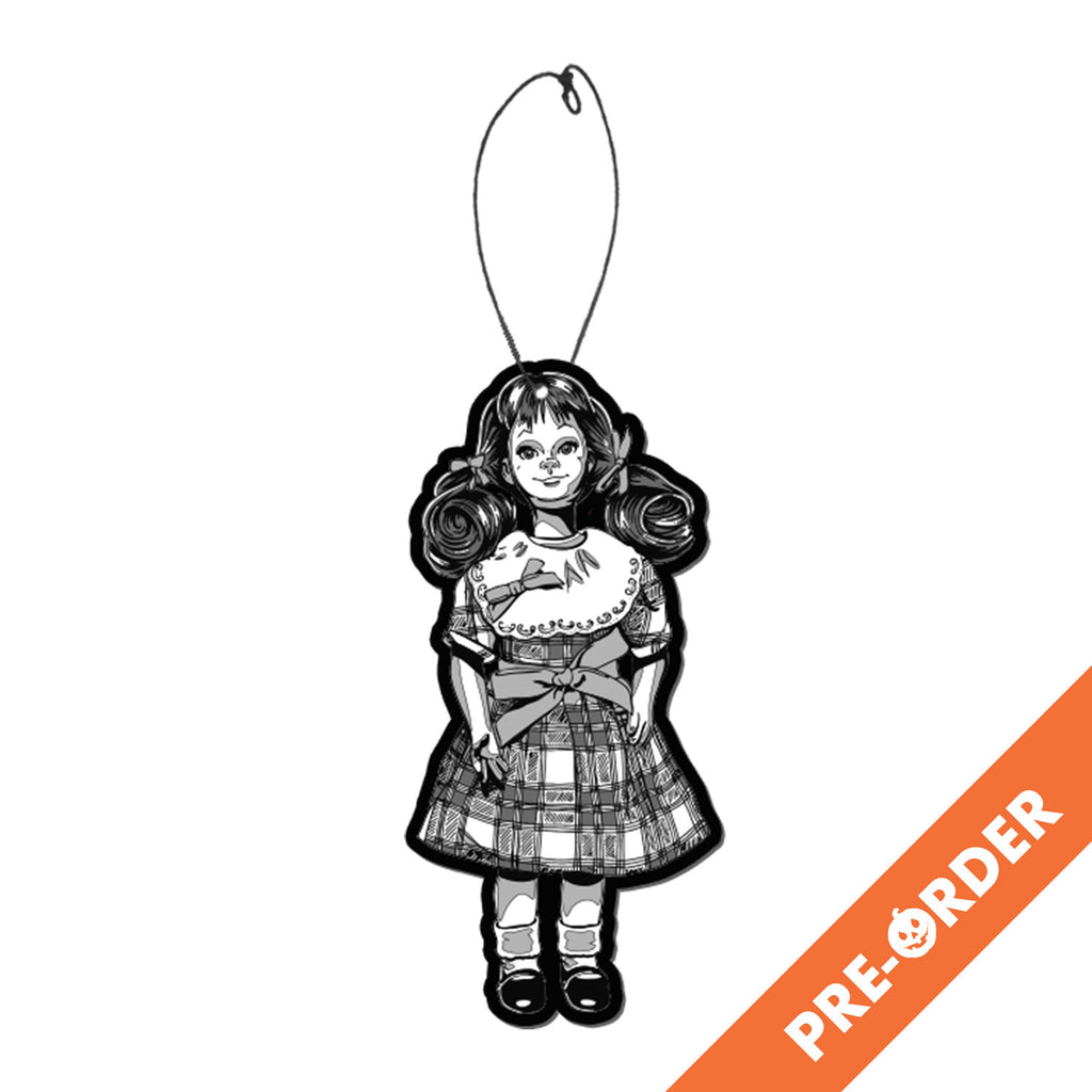 white background, orange diagonal banner at bottom right, white text reads pre-order.  Air freshener. Black and white illustration, Talky Tina doll wearing plaid dress, with bow at waist, hair in two ponytails with bows. Black shiny dress shoes, white socks.