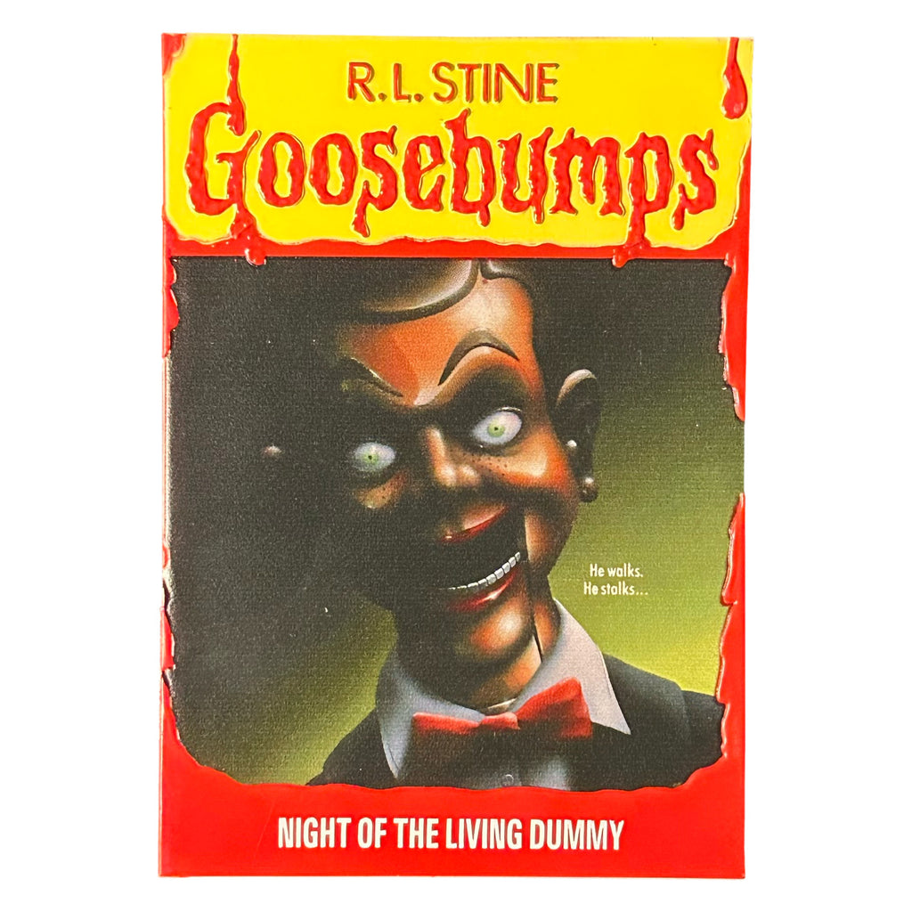 Magnet. Has the appearance of a book cover. Illustration of a menacing ventriloquist dummy with a black and green background. Yellow banner at top, red text reads R.L. Stine, Goosebumps. White text on illustration reads He walks, He stalks. Red border at bottom, white text reads Night of the Living Dummy. 