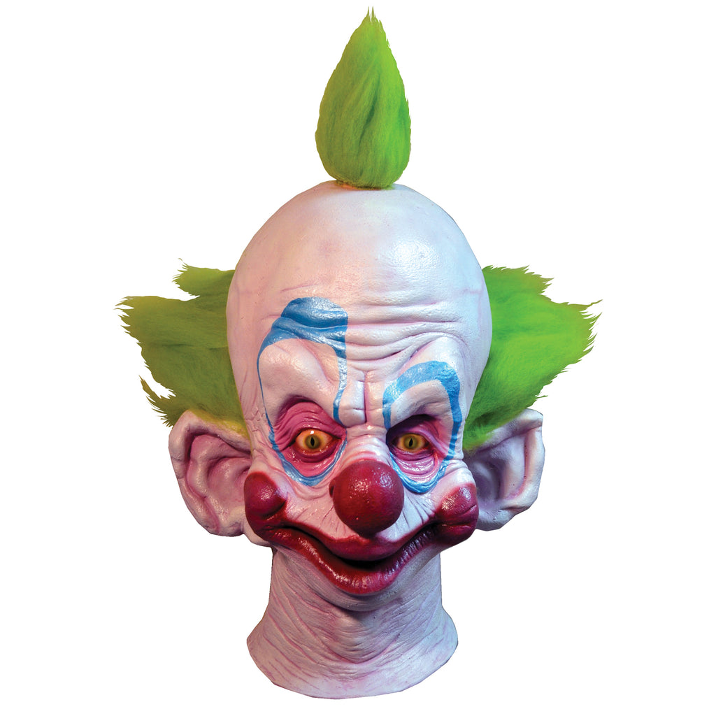 Mask, head and neck. Exaggerated clown face. White skin, bright green tuft of hair on top of head and bright green hair on sides of head. Blue eyebrows and pink around eyes. Red large nose, cheeks and lips. Large pointed low-set ears.