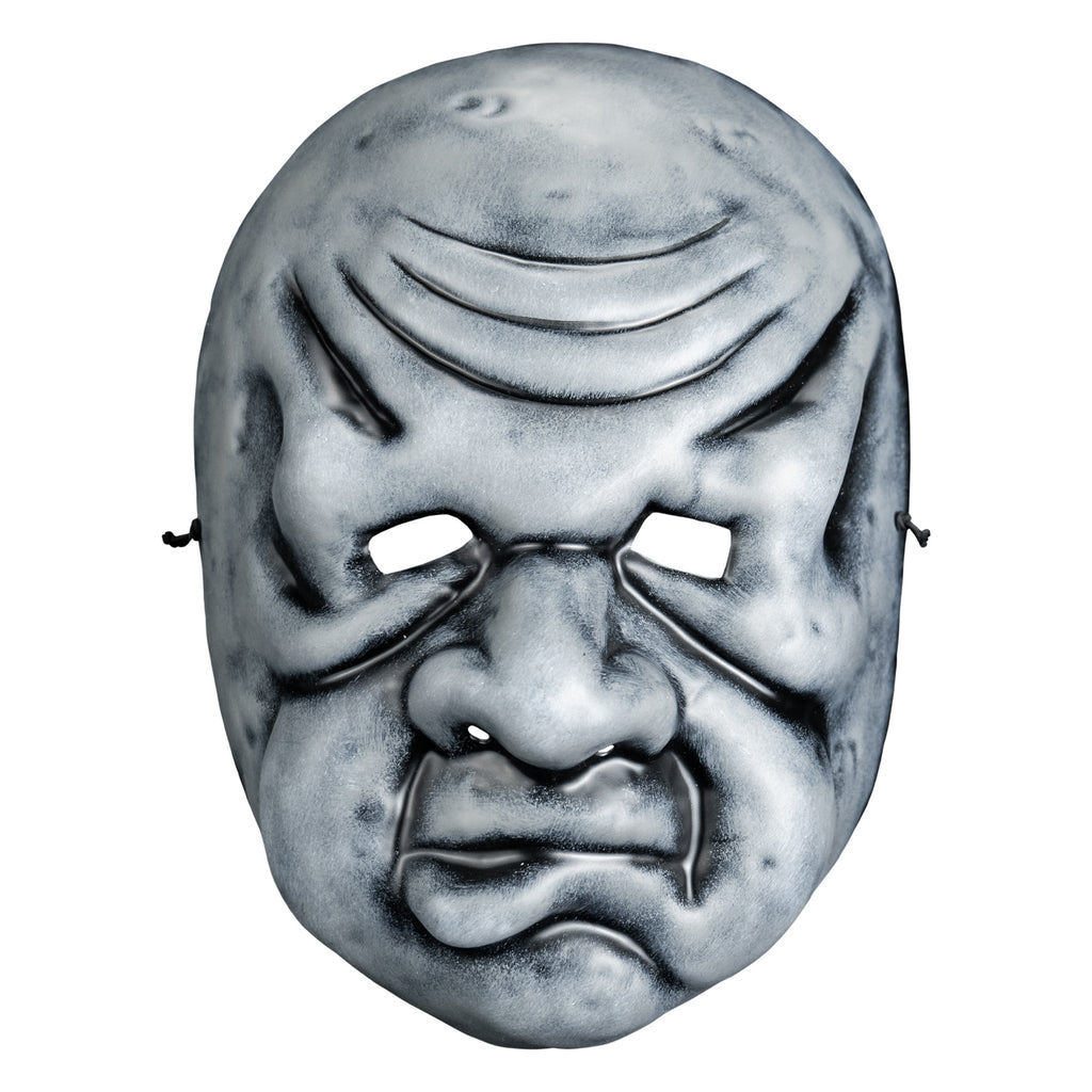 Mask, front view. Black and white toned face mask. Bald, wrinkles on forehead, no eyebrows, bags under small eyes, short fat nose, heavy jowls, mouth with misshapen lower lip.